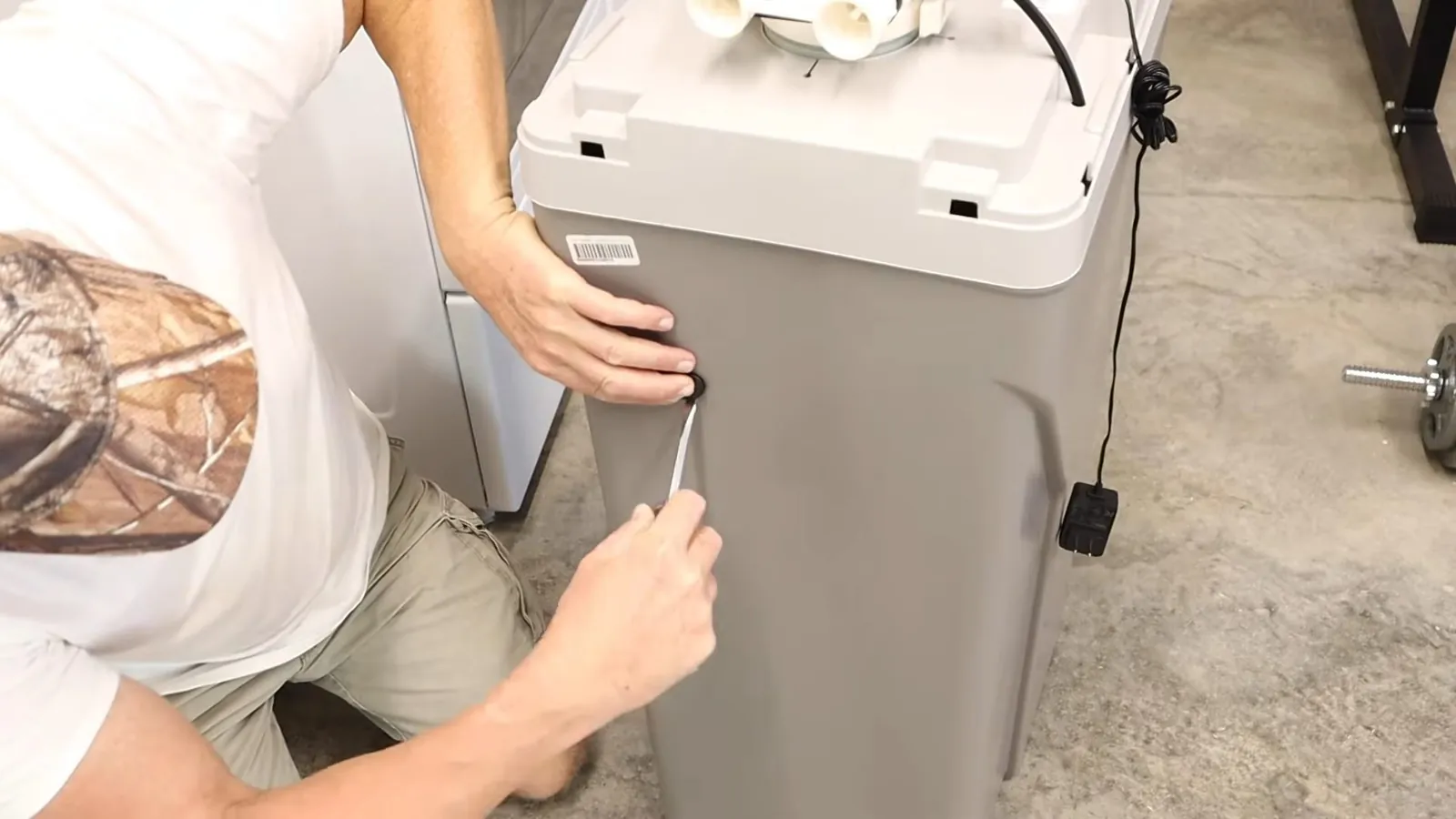 Close-up of the technician positioning water softener cabinet on a residential plumbing job near Federal Way.